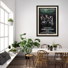 a dining room table with chairs and a movie poster hanging on the wall above it