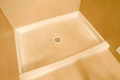 a shower head in the middle of a tiled floored bathroom with beige walls and floors