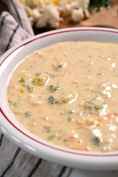 a bowl of soup with broccoli and cauliflower in it on a table