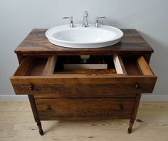 a bathroom sink sitting on top of a wooden cabinet