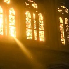 the sun is shining through two windows in an old building with stained glass and wood trim