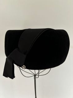 "Striking black wool hat with satin side ribbon and embellished with a small rhinestone covered ball.  The truly STANDOUT FEATURE of this topper is its wonderful architectural shape. Black hats are hard to photograph. This has is ultra flattering and cool looking on, its a shame I don't have a model to illustrate this. Hat body \"made in Italy by Roma of the highest quality velour\". In great condition, with the only issue being the fraying at the bottom of the knotted ribbon.  But there are various solutions for this: hem it or cut it shorter, bring end into hat interior and secure.  Comes from non-smoking home. Thanks for shopping Small And Sustainable!" Black Wool Hat, Black Hats, Velvet Hat, Floral Tablecloth, Pill Boxes, Black Hat, Wool Hat, Black Wool, Black Velvet