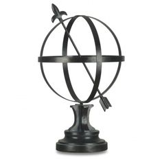 a metal globe with an arrow on it's end and a black base is shown against a white background