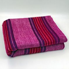 two purple and red striped blankets folded on top of each other in front of a white background