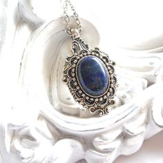 A lovely ornate pendant necklace in victorian style with a lapis  lazuli cabochon. Beautiful pendant hand made with silver tone components. Due to the natural origin of the cabochon, differences in color may occur. Cabochon size 13 x 18 mm. It is finished with a dainty chain. The chain measures approximately 50 cm. (21 inches) For more jewelry please visit our shop: http://minouc.etsy.com We also combine shipping with our other Etsy shop where we sell vintage fabrics and finds from Holland and F Vintage Blue Cabochon Jewelry, Blue Vintage Cabochon Jewelry, Ornate Blue Nickel-free Jewelry, Ornate Nickel-free Blue Jewelry, Blue Vintage Charm Jewelry Gift, Victorian Style Blue Round Pendant Jewelry, Antique Blue Oval Pendant Jewelry, Victorian Blue Gemstone Necklace, Blue Bohemian Necklace With Vintage Charm