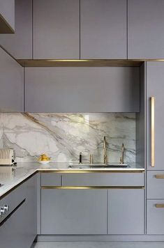 a kitchen with marble counter tops and white cabinets