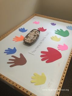 a wooden table topped with lots of handprinted hands on top of it and a piece of wood in the middle