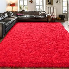 a living room with a large red rug on the floor