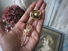 A classic vintage gold plated single stemmed rose pin/brooch accented with two faux pearls. It measures 4 1/4'' long x over 1 1/4'' at widest. The head of the rose swivels. In very good condition. Vintage Rose Gold Brooches For Wedding, Vintage Rose Gold Wedding Brooches, Formal Gold Brooch With Rose Design, Vintage Rose Brooch For Gift, Vintage Rose Brooches For Gifts, Vintage Rose Brooches As Gift, Rose Gold Brooch With Rose Design For Weddings, Vintage Pearl Brooch, Pearl Paint