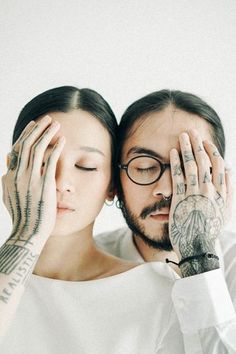 a man and woman with tattoos covering their faces