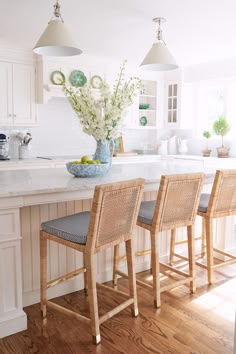 three chairs sitting at the end of a kitchen island