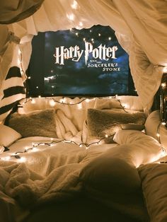 a harry potter poster on the wall above a bed with pillows and blankets covered in lights