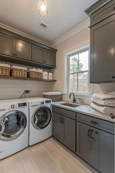 a washer and dryer sitting in a kitchen next to a window with lots of cabinets