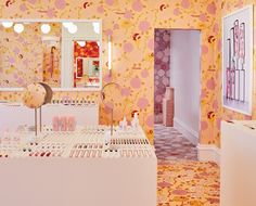 the inside of a nail salon with pink and yellow flowers on the walls, mirrors, and manicures