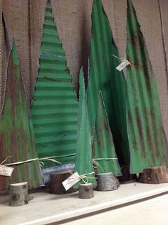 green tin trees are sitting on a shelf in front of a wall with tags attached to them