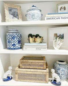 the shelves are filled with vases, books and other decorative items in blue and white