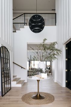 an open floor plan with white walls and wooden floors, large chandelier above the table