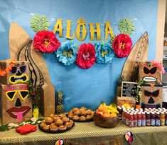 an aloha themed dessert table with cupcakes, muffins and fruit