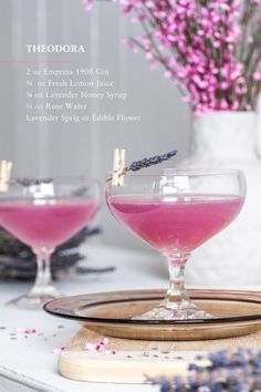 two glasses filled with pink liquid and lavender sprinkles