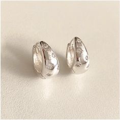 ✶ Chunky Droplet Star Huggie Hoop Earrings ✶ ✶ Material : Sterling silver ✶ Dimension : W15mm x L14mm, T 6.8mm ✶ Free shipping on UK orders ✶ The Chunky Droplet Star Huggie Hoop Earrings feature a bold, droplet-shaped hoop with a sparkling star cut, set with dazzling cubic zirconia. Twinkling with every movement, these earrings add a touch of celestial charm to any look. ✶ Each piece of our jewellery is lovingly handcrafted with care and creativity. As passionate jewellery lovers, we ensure you wear not just an accessory, but a unique piece of art infused with our dedication. ✶ Sterling Silver Jewellery Care Instructions: * Store Properly: Keep your Jewellery in a soft pouch or a Jewellery box to prevent scratching and tarnishing. *  Avoid Moisture: Remove Jewellery before washing hands, s Chunky Sterling Silver Earrings, Unique Jewelry Silver, Chunky Silver Jewelry, Cute Silver Earrings, Chunky Silver Earrings, Chunky Silver Jewellery, Star Hoop Earrings, Chunky Earrings, Silver Jewelry Earrings