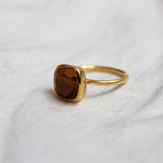 D E T A I L S - Material: Sterling Silver 925 Stone: Tiger Eye The Fit: True to US ring size Finish: Smooth and gold-plated to a high shine About Tiger Eye- Its golden-yellow colour represents the ability of manifestation, while its brown colour the energies of the Earth. Thus, tiger's eye helps in the manifestation of ideas on the physical level. Tiger Eye conveys an important message. The message of this birthstone of Gemini is that the physical level is a playing field where our Spirit can ma Gift Yellow Gold Gemstone Midi Rings, Yellow Gold Gemstone Midi Rings As Gift, Gift Yellow Gold Midi Rings With Gemstones, Sterling Silver Rings With Bezel Setting As Gift, Adjustable Bezel Setting Midi Rings For Gift, Classic Handmade Stackable Rings As Gift, Sterling Silver Ring With Bezel Setting Gift, Adjustable Bezel Setting Midi Rings As Gift, Adjustable Bezel Set Ring As A Gift