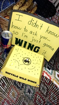 a yellow sign sitting on top of a table next to a can of soda and some bananas