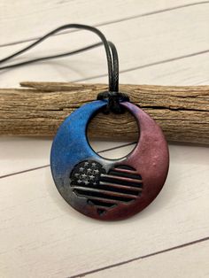 a necklace with an american flag in the shape of a crescent on a black cord