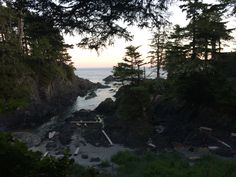 the ocean is surrounded by trees and rocks