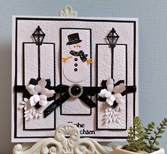 a card with a snowman on it sitting next to a potted plant