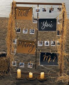 a sign that says, will you marry me? with candles in front of it