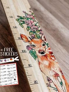 a wooden ruler with an image of a deer on it's face and flowers