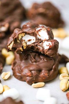 chocolate covered cookies with marshmallows and nuts on the top one is broken in half