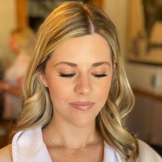 a woman is getting her make - up done at the salon and she has long blonde hair