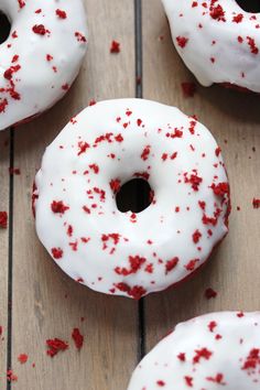 white donuts with red sprinkles on wooden table