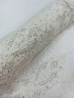 the back of a white wedding dress with sequins on it and sheer fabric