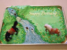 a birthday cake decorated with horses and stream