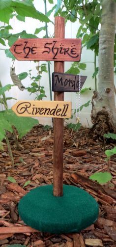 a wooden sign that is on top of some wood planks in the ground with leaves around it