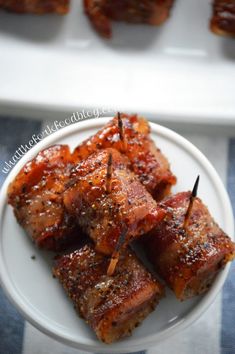 several pieces of meat on a plate with toothpicks