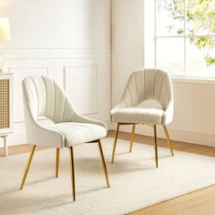 two white chairs sitting next to each other on top of a carpeted floor in front of a window