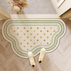 two pairs of sneakers are sitting on the floor next to a rug with an ornate design