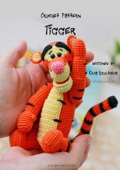 a crochet pattern of a small stuffed tiger holding onto a finger with the caption tiger