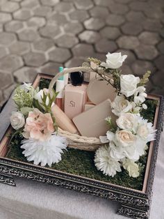 an arrangement of flowers and personal care items in a basket on top of a table