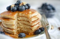 a stack of pancakes with blueberries and syrup