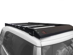 the roof rack is mounted on top of a white van with black trim and metal bars