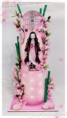 a pink cake decorated with an image of a geisha doll on it's side