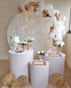 three white round tables with gold and white decorations on the top one is decorated with balloons