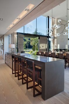 a large kitchen with wooden floors and an island countertop in front of glass windows