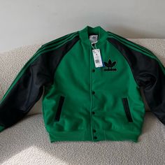 Almost Out Of Stock. A Few Pieces In Farfetch For $273. This Lightweight Bomber Jacket Features Bold Color Combos And A Unique Chenille Trefoil Badge. Beyond The Way It Looks, You Can Count On The Loose Layer-Ready Shape And Excellent Insulation Properties When The Temperature Dips. Now That's What We Mean By Fashion-Meets-Function. Loose Fit Full Snaps With Ribbed Bomber Collar Shell: 55% Recycled Polyester, 40% Acrylic, 5% Wool Single Jersey Sleeves: 100% Polyurethane Leather Inside Welt Pocke Red Adidas Jacket, Rita Ora Adidas, Adidas Jacket Women, Sport Sweater, Adidas Windbreaker, Adidas Track Jacket, Black Zip Ups, Red Adidas, Striped Sleeve