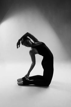 black and white photograph of a woman sitting on the floor with her hands behind her head