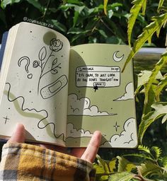 someone is holding an open book with drawings on it